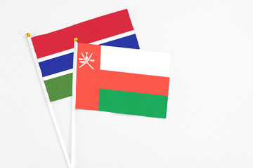 Oman and Georgia stick flags on white background. High quality fabric, miniature national flag. Peaceful global concept.White floor for copy space.