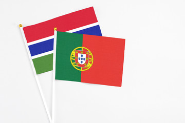 Portugal and Georgia stick flags on white background. High quality fabric, miniature national flag. Peaceful global concept.White floor for copy space.