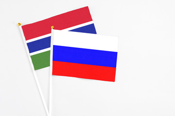 Russia and Georgia stick flags on white background. High quality fabric, miniature national flag. Peaceful global concept.White floor for copy space.
