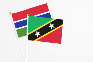 Saint Kitts And Nevis and Georgia stick flags on white background. High quality fabric, miniature national flag. Peaceful global concept.White floor for copy space.