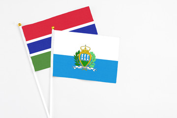 San Marino and Georgia stick flags on white background. High quality fabric, miniature national flag. Peaceful global concept.White floor for copy space.