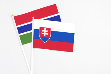 Slovakia and Georgia stick flags on white background. High quality fabric, miniature national flag. Peaceful global concept.White floor for copy space.