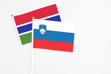 Slovenia and Georgia stick flags on white background. High quality fabric, miniature national flag. Peaceful global concept.White floor for copy space.