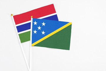 Solomon Islands and Georgia stick flags on white background. High quality fabric, miniature national flag. Peaceful global concept.White floor for copy space.