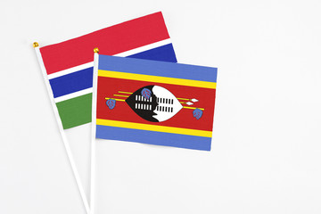 Swaziland and Georgia stick flags on white background. High quality fabric, miniature national flag. Peaceful global concept.White floor for copy space.