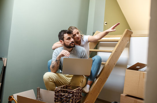Young couple moving into new home.They using laptop and looking for design interior ideas online.