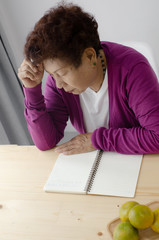 Asian senior woman  writing notebook at home, lifestyle concept.