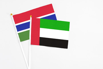 United Arab Emirates and Georgia stick flags on white background. High quality fabric, miniature national flag. Peaceful global concept.White floor for copy space.