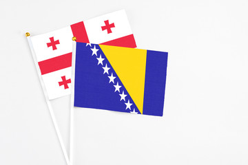 Bosnia Herzegovina and Georgia stick flags on white background. High quality fabric, miniature...