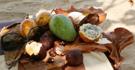 Still life from tropical fruit, tree leaves, mango green color: passion fruit in fault and whole fruit