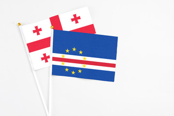 Cape Verde and Georgia stick flags on white background. High quality fabric, miniature national flag. Peaceful global concept.White floor for copy space.
