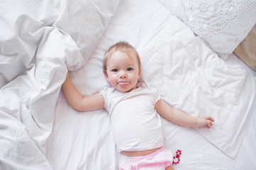 Portrait of a baby boy on the bed in bedroom 