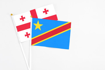 Congo and Georgia stick flags on white background. High quality fabric, miniature national flag. Peaceful global concept.White floor for copy space.