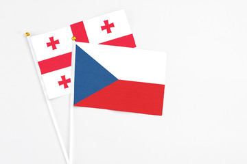Czech Republic and Georgia stick flags on white background. High quality fabric, miniature national flag. Peaceful global concept.White floor for copy space.