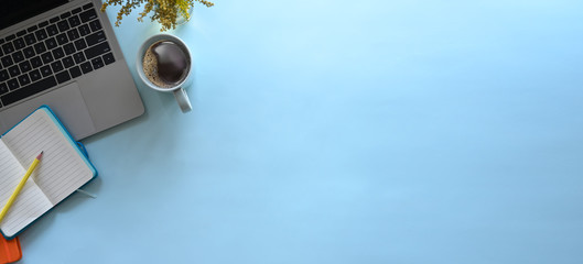 Simple Top view table - Creative flat lay office desk. Laptop, notebooks and coffee cup on blue...