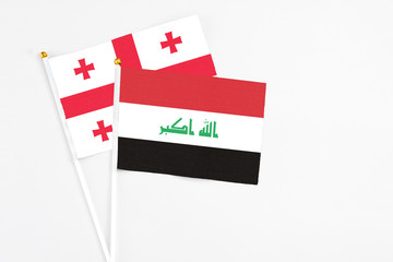 Iraq and Georgia stick flags on white background. High quality fabric, miniature national flag. Peaceful global concept.White floor for copy space.