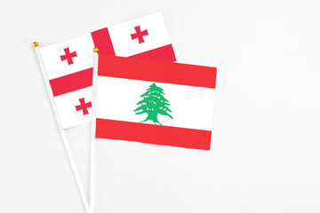 Lebanon and Georgia stick flags on white background. High quality fabric, miniature national flag....