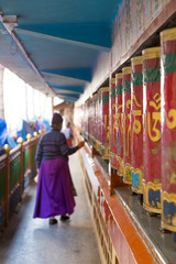 Fototapeta premium Woman spinning prayer wheels in India
