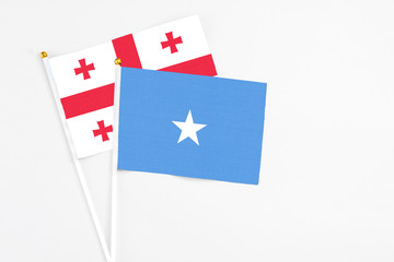 Somalia and Georgia stick flags on white background. High quality fabric, miniature national flag. Peaceful global concept.White floor for copy space.