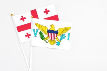 United States Virgin Islands and Georgia stick flags on white background. High quality fabric, miniature national flag. Peaceful global concept.White floor for copy space.