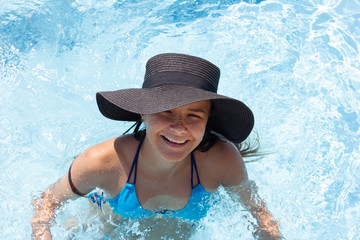 Young beautiful girl in a hat by the pool, top view