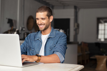 Happy guy using laptop - obrazy, fototapety, plakaty