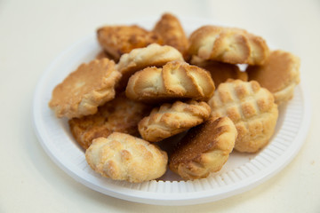 Oven fresh cookies and biscuits served in plate. baked toast garlic bread isolated on white background . variety of biscuit on plate isolated on white .