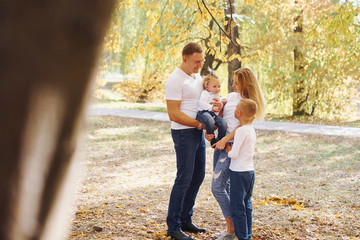 Cheerful young family have a walk in an autumn park together