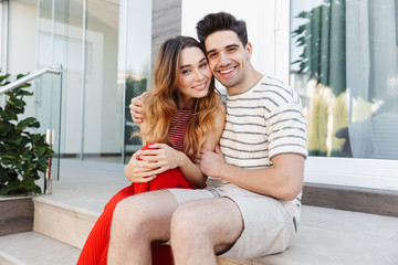 Obraz premium Image of happy caucasian couple smiling and hugging while sitting