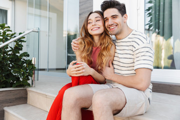 Obraz premium Image of happy caucasian couple smiling and hugging while sitting