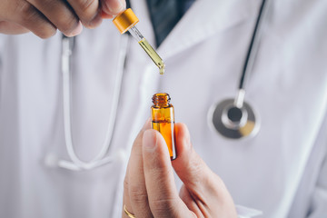 Doctor holding a bottle of hemp oil.CBD Hemp oil.