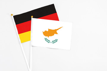 Cyprus and Germany stick flags on white background. High quality fabric, miniature national flag. Peaceful global concept.White floor for copy space.