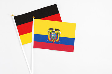 Ecuador and Germany stick flags on white background. High quality fabric, miniature national flag. Peaceful global concept.White floor for copy space.