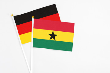 Ghana and Germany stick flags on white background. High quality fabric, miniature national flag. Peaceful global concept.White floor for copy space.