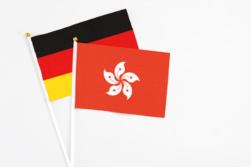 Hong Kong and Germany stick flags on white background. High quality fabric, miniature national flag. Peaceful global concept.White floor for copy space.