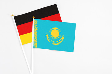 Kazakhstan and Germany stick flags on white background. High quality fabric, miniature national flag. Peaceful global concept.White floor for copy space.