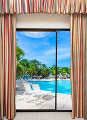 Fototapeta na wymiar a swimming pool with sun loungers open window