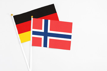 Norway and Germany stick flags on white background. High quality fabric, miniature national flag. Peaceful global concept.White floor for copy space.