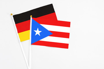 Puerto Rico and Germany stick flags on white background. High quality fabric, miniature national flag. Peaceful global concept.White floor for copy space.