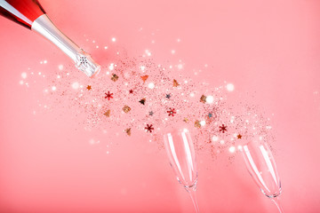 Christmas concept. Pink champagne, sparkles and a pair of glasses.
