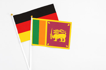 Sri Lanka and Germany stick flags on white background. High quality fabric, miniature national flag. Peaceful global concept.White floor for copy space.