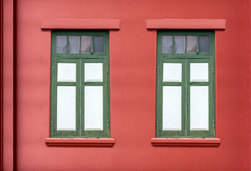 Fototapeta na wymiar Traditional windows on bright red walls