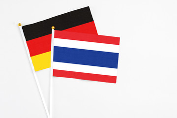 Thailand and Germany stick flags on white background. High quality fabric, miniature national flag. Peaceful global concept.White floor for copy space.