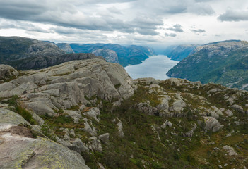 Fototapeta na wymiar View on fjord Lysefjord, next to Preikestolen massive cliff famous Norway viewpoint Moody sky, autumn day. Nature and travel background, vacation and hiking holiday concept.