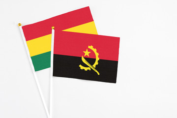 Angola and Ghana stick flags on white background. High quality fabric, miniature national flag. Peaceful global concept.White floor for copy space.
