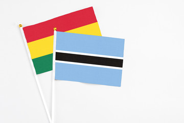 Botswana and Ghana stick flags on white background. High quality fabric, miniature national flag. Peaceful global concept.White floor for copy space.