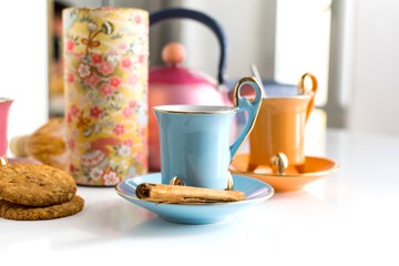 Set of vintage colorful cups of tea with cookies and teapot close-up. Infusion, breakfast and morning concept.