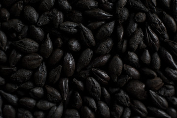 Black roasted malt for alcohol production. Roasted Barley background. Top view