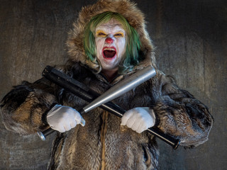 Crazy aggressive clown with baseball bat. man hates his work and in his free time dresses like...