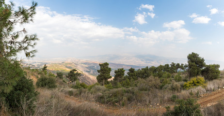 Fototapeta na wymiar Panoramic view from the Bania observation deck near the Israeli Misgav Am village to the valley in the Upper Galilee, Golan Heights and Mount Hermon in northern Israel and South Lebanon